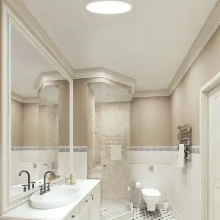 Bathroom vanity and tiled shower lit by a tubular skylight
