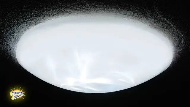 White dome ceiling lens of a tubular skylight glowing with daylight