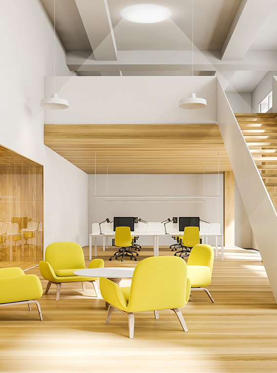 Bright office lounge with yellow chairs lit by a ceiling tubular skylight