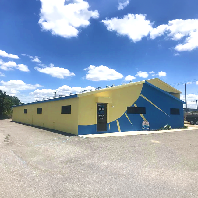 Tubular Skylight building painted yellow and blue with skylight domes on the roof