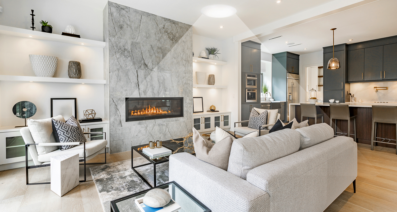 Living room with a sofa and marble fireplace wall brightened by a tubular skylight